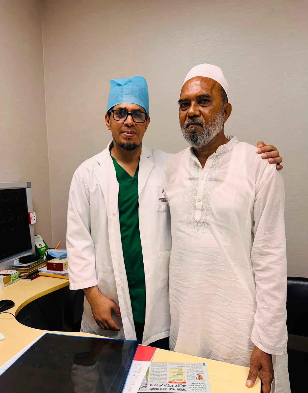 Dr. Zico standing beside an older patient in a white kurta at the clinic