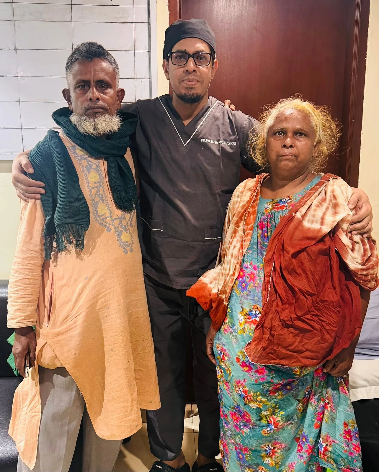 Dr. Zico standing between a patient and a family member in the consultation room